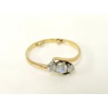A gold diamond three stone crossover ring, marked 18ct, size O