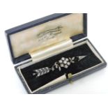 A Victorian diamond floral cluster and arrow brooch, set in silver and backed in gold, tested as