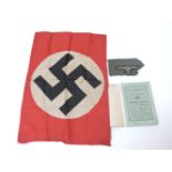 A WWII swastika flag taken from a tank, a German military arm badge cut from a uniform, and a German