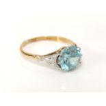 A gold single stone blue zircon ring, with millegrain effect shoulders