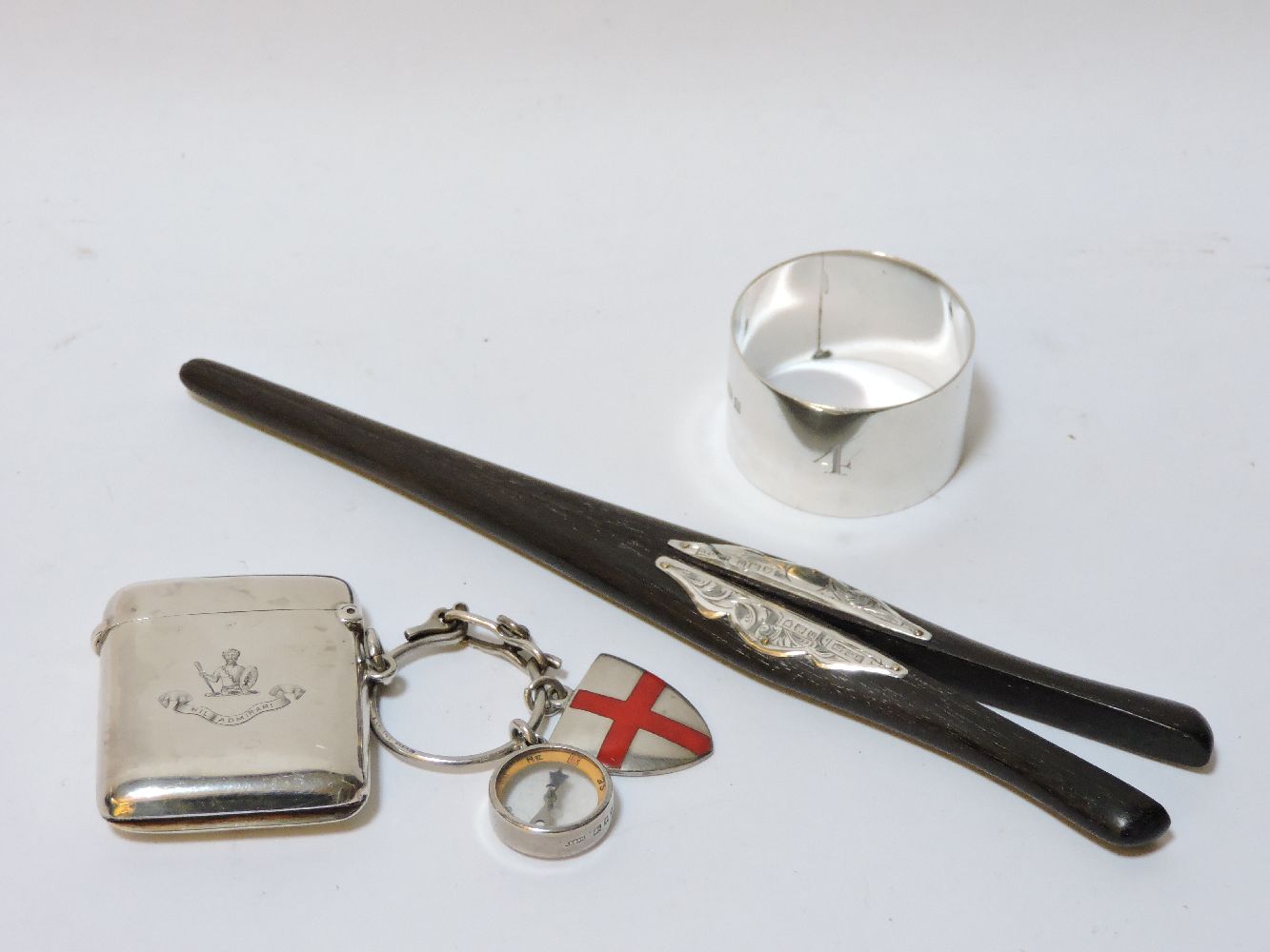 A silver vesta case, a crested silver napkin ring, and ebony glove stretchers