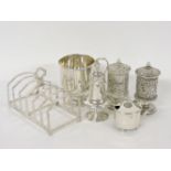 Silver items, comprising a toast rack, a christening mug, a pepper, a mustard, and two Indian pepper