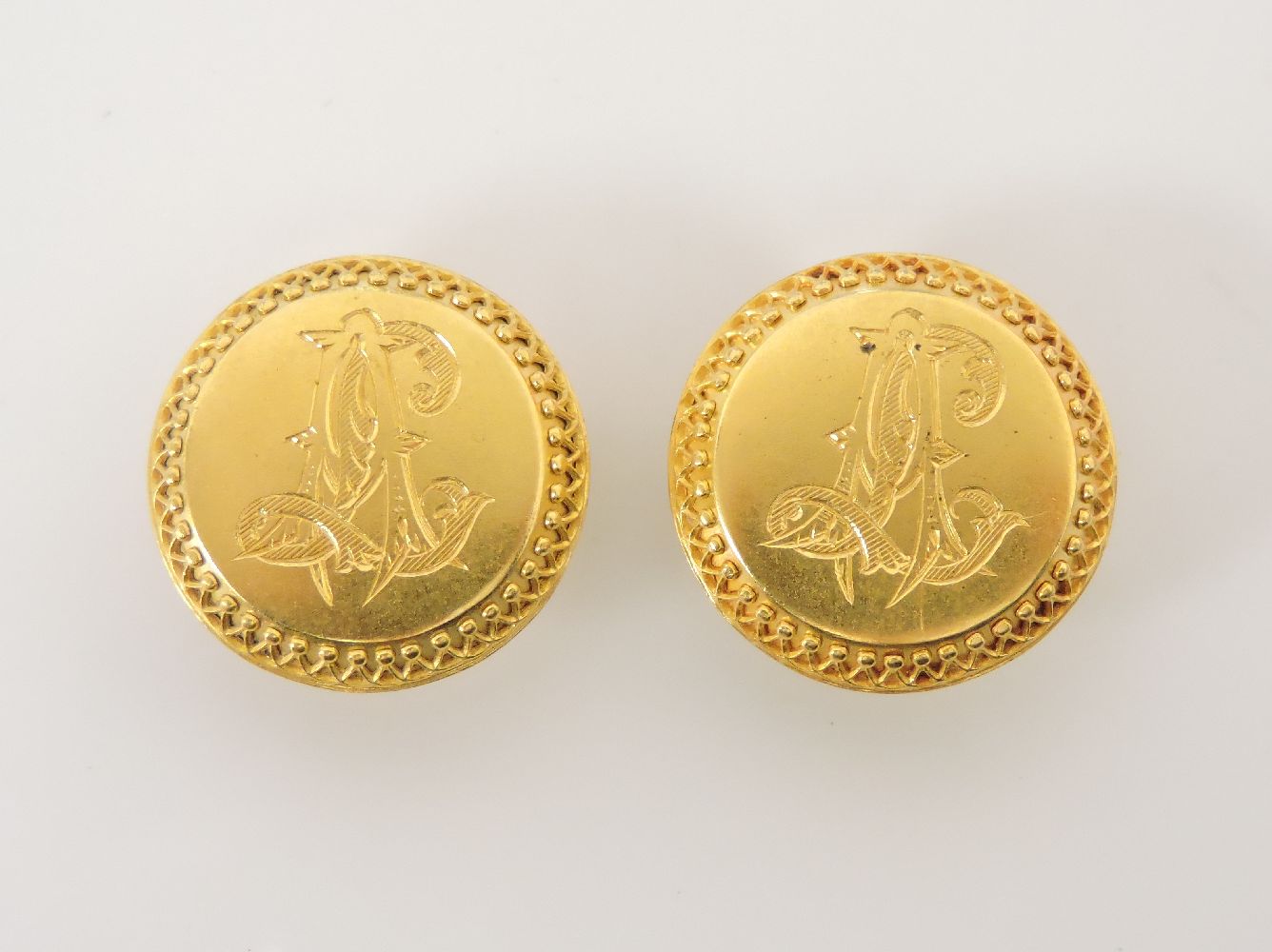 A pair of Victorian gold studs, with hand engraved monogram and raised decorative border, tested