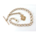 A 9ct gold graduated curb link guard chain, with 9ct bar and 9ct gold shield fob with vacant