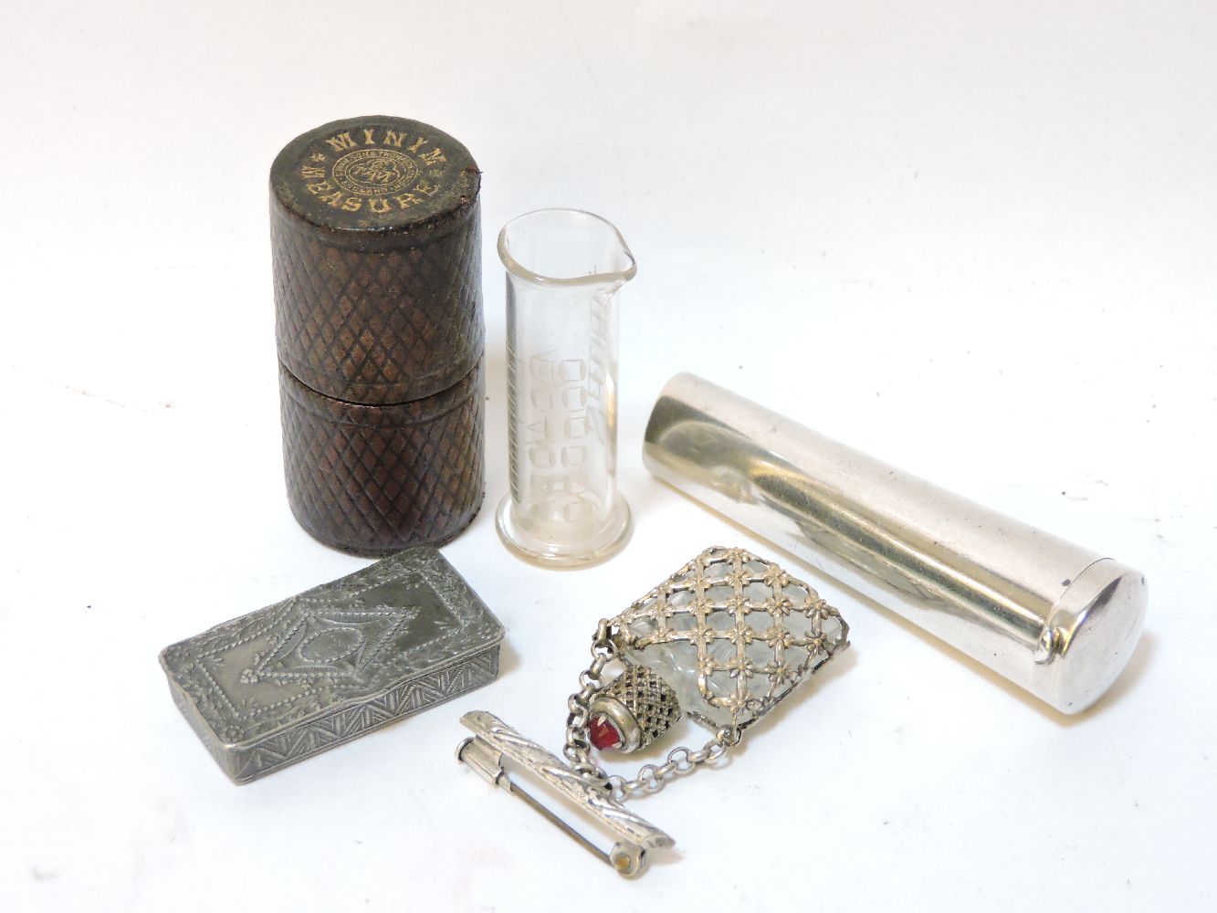 A silver cheroot holder case, a miniature scent bottle/brooch, a pewter miniature snuff box, and a