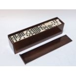 A set of dominoes, bone and ebony, in a mahogany box