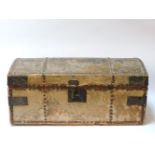 A pony hide trunk, with a dome top, the interior with printed paper, with iron carrying handles,