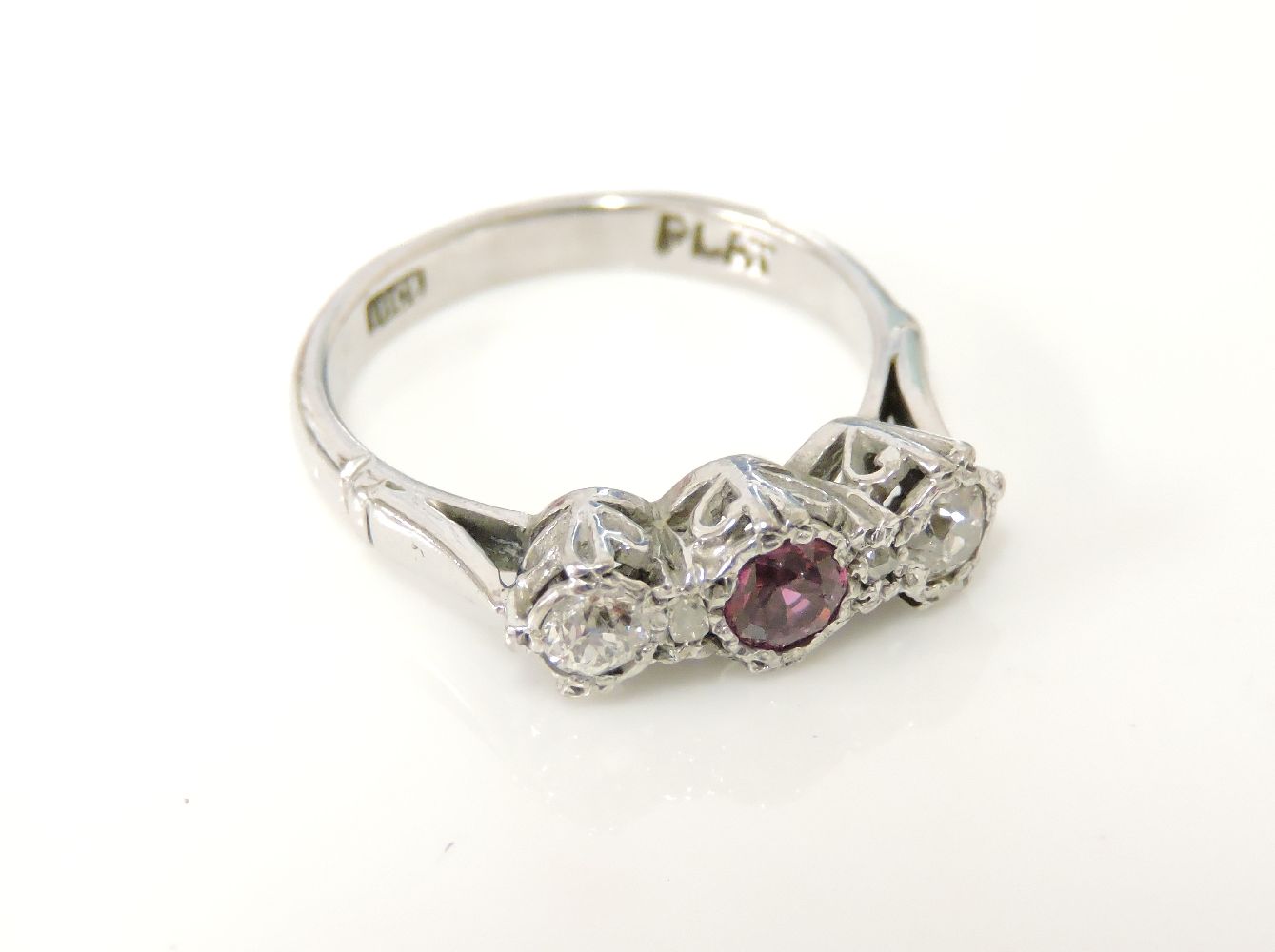 A three stone ruby and diamond ring, with a pair of diamond points, marked plat and 18ct, 3.5g