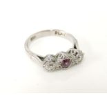 A three stone ruby and diamond ring, with a pair of diamond points, marked plat and 18ct, 3.5g