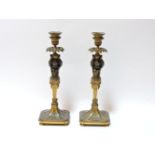 A pair of gilt bronze candlesticks, modelled as putti holding sconces aloft, 31.5cm high