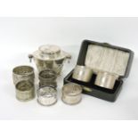 A silver tea caddy, a cased pair of napkin rings, three further silver rings, and two others