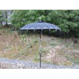 A black Oriental parasol, with silvered decoration