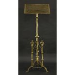 A Victorian brass lectern, with a pierced book rest, raised on a turned central column, with three