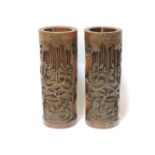 A pair of carved bamboo brush pots, each decorated with seven scholars of bamboo grove, each with