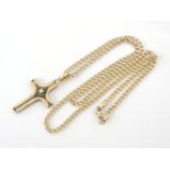 A gold single stone brilliant cut diamond cross, on a curb link chain, tested as approximately