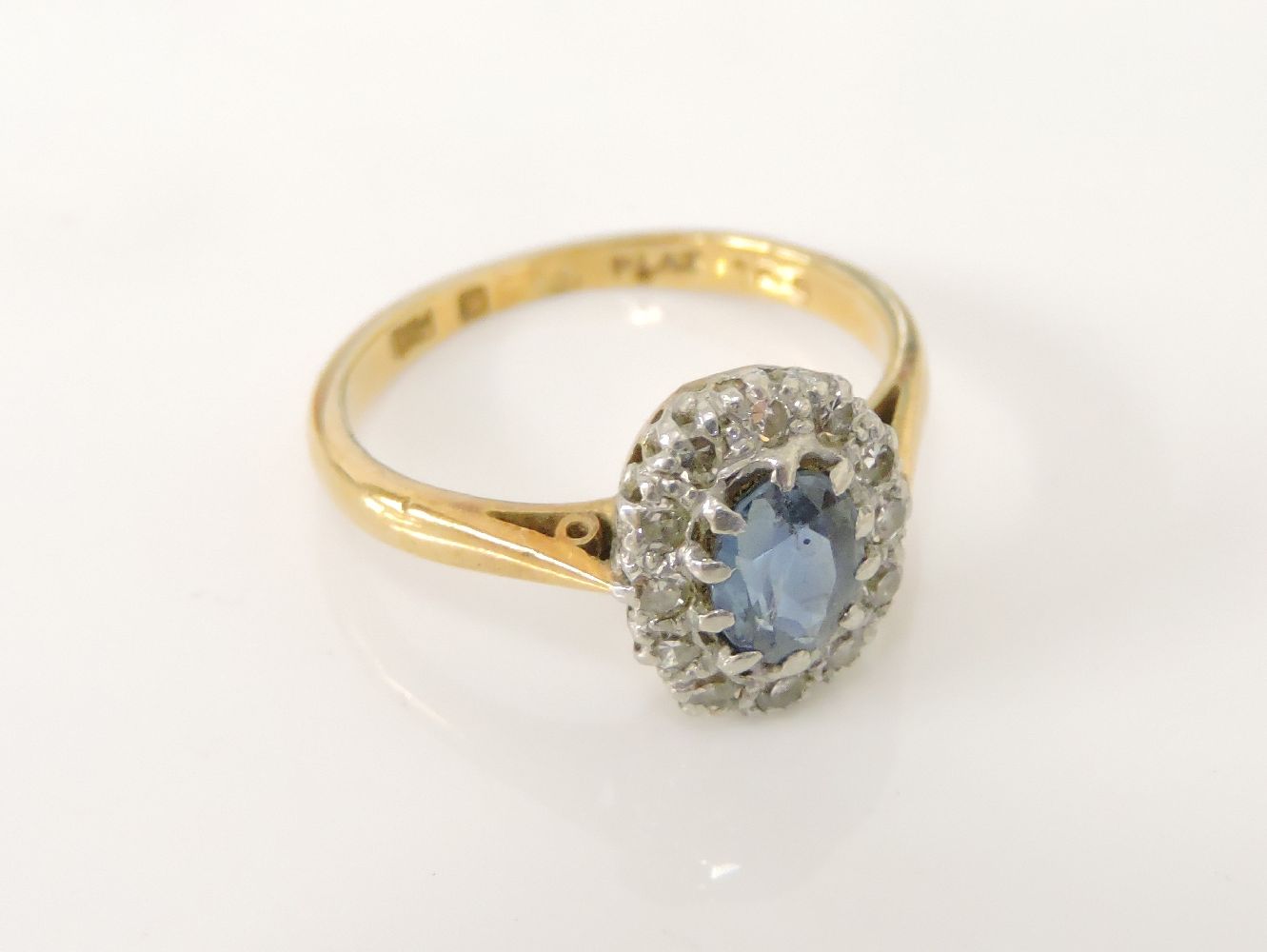 An oval cut sapphire and diamond cluster ring, marked 18ct and plat, 3.21g