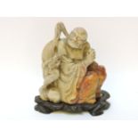 A Chinese soapstone figure, on a stand, 12cm high