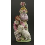 A Chelsea gold-mounted porcelain scent bottle,modelled as a shepherdess, seated by a vase on a