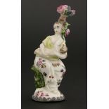 A Chelsea porcelain scent bottle,modelled as a lady cradling her baby, sitting by a tree, the