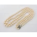 A two row graduated cultured pearl necklace, with a metal filigree clasp