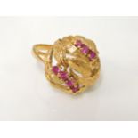 A Continental gold bombé style ring, with textured leaf head and two rows of seven synthetic rubies,
