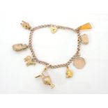 A 9ct gold curb link charm bracelet, with eight assorted charms including a 9ct gold handbag, a