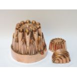 A large copper jelly mould, and two further moulds, 14cm high, 15cm diameter