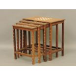 A mahogany nest of tables with decorative inlay, the largest with a chess board to top, 54cm high,