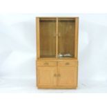 A modern Ercol light elm cabinet, glazed upper section over cupboards beneath, 91cm wide