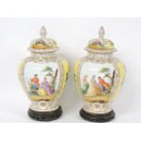 A pair of Dresden jars and covers, the panelled decoration within gilt borders with wooden studs,