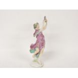 A Continental porcelain figure of a lady playing a tambourine, 23cm high (damage)