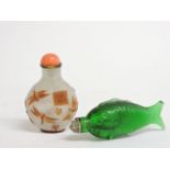 Two Chinese snuff bottles and stoppers, one moulded in green glass as a fish, and one overlaid in