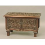 A small late 19th / early 20th century carved box, decorated with roses and a sunflower, and a