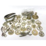 A collection of horse brasses, brass curtain rings, leather straps, etc.