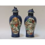 A pair of blue ground vases and covers, late 19th century, each with quatreform panels of either