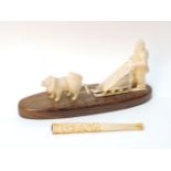 A Chinese carved ivory cigarette holder, together with a North American walrus ivorine sleigh with
