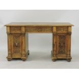 A Victorian light oak pedestal desk, with three frieze drawers, carved with strap work, over