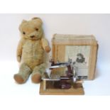 An old teddy bear, gold plush, 46cm tall, and a child's sewing machine, 'The Essex'