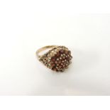 A 9ct gold garnet cluster ring, with textured open work shoulders