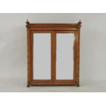 A satin walnut cabinet, with mirrored doors, with simulated bamboo moulding, opening to reveal three