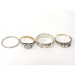 A gold single stone illusion set ring, marked 18ct, a three stone paste ring, a silver facetted