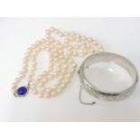 A single row uniform cultured pearl necklace, with a gold and lapis lazuli cabochon clasp, marked