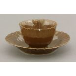 An early 18th century rare fluted tea bowl and saucer, each piece entirely covered in a reddish-