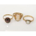 A 9ct gold garnet cluster ring, a gold single stone opal ring marked 9ct, and a 9ct gold shell cameo