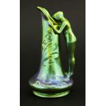 A Zsolnay Pécs pottery ewer, with iridescent eosin glaze of a maiden peering into an ewer, printed