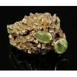 A 9ct gold two-stone peridot ring, c.1970,with a circular mixed cut and pear cut peridot, both rub