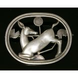 A sterling silver kneeling deer brooch,by Georg Jensen, designed by Arno Malinowski, the kneeling