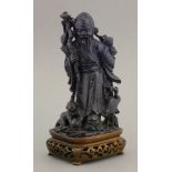 A lapis lazuli Shoulao, 20th century, standing with gnarled staff and peaches above a boy and crane,