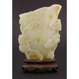A good jade lotus Libation Pourer,possibly 18th century, the pale green stone suffused with toffee