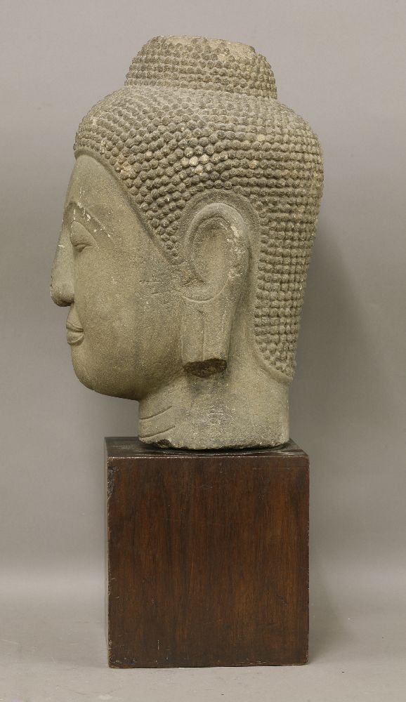 A carved stone bust of Buddha,19th century or later, serenely modelled, on a wood block base,bust - Image 2 of 3